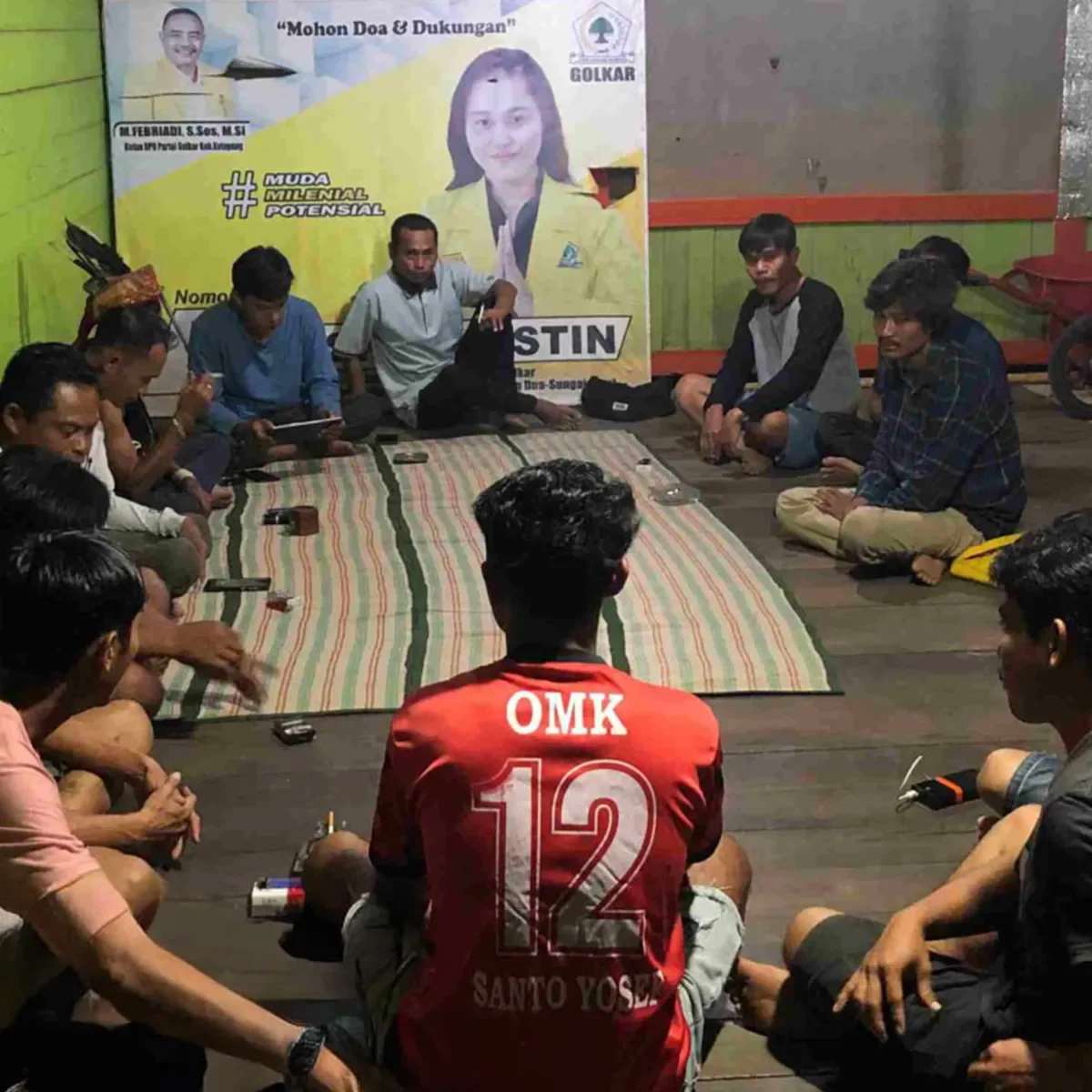 Community members seated in a circle indoors during a group discussion or workshop session.